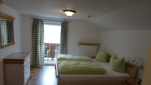 A bedroom with two beds, a dresser, and a radiator. - Apartment Anna for 4 persons, 2 bedrooms, kitchenette, bathroom, 72 sqm (Inzell)