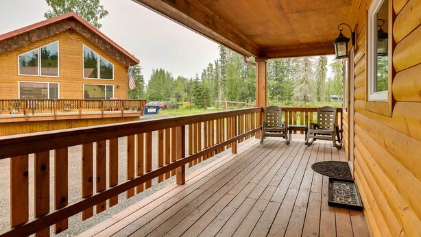 A wooden cabin with a deck, a covered porch, and a view of a forest. - Fisherman’s Cabin in Soldotna Near Kenai River! (Soldotna)