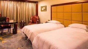 A hotel room with two beds, a desk with a chair, a television, and a large window with curtains. - Jinou Hotel (Wenzhou)