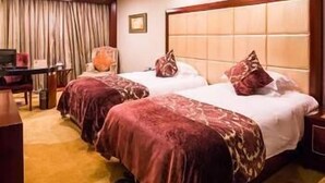 A hotel room with two beds, a desk, and a chair. - Jinou Hotel (Wenzhou)