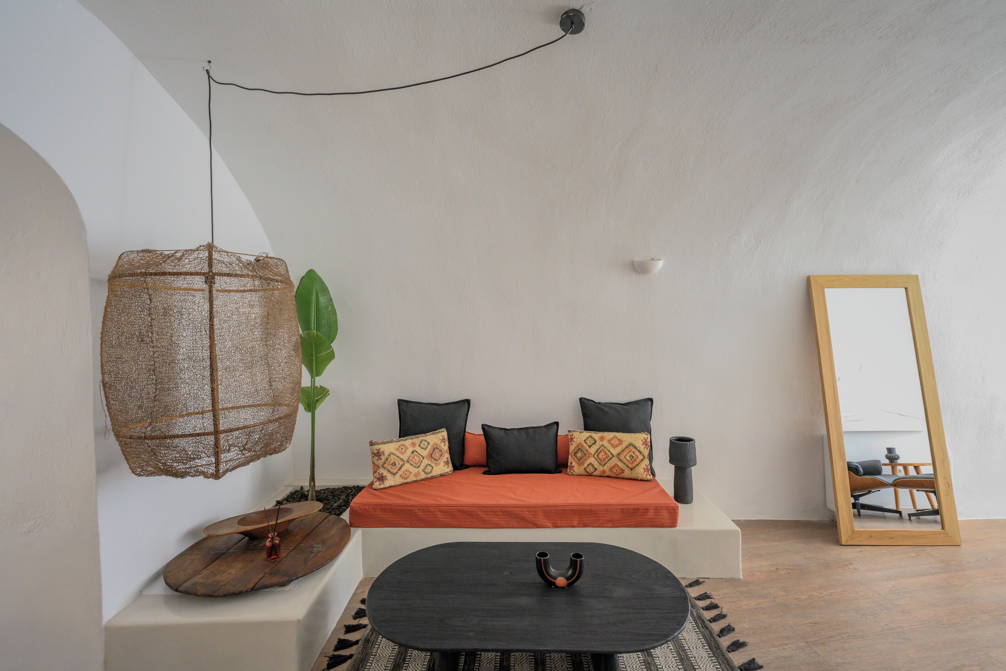 A modern bedroom with a bed, bedside table, and a hanging light fixture.