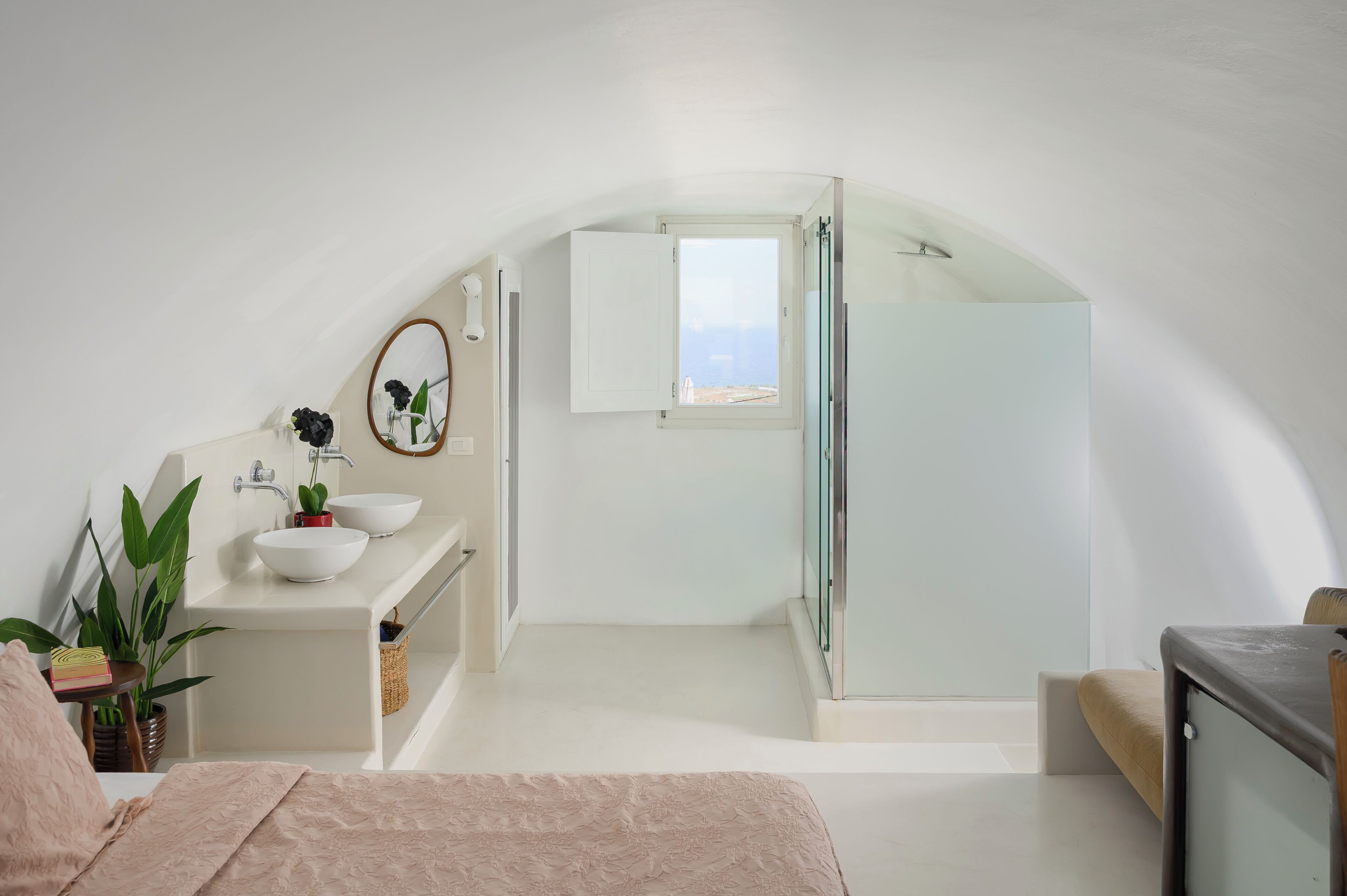A modern bathroom with a white sink, mirror, and shower.