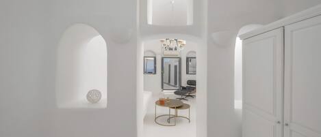 Un intérieur moderne avec des murs blancs, une table ronde et un lustre.