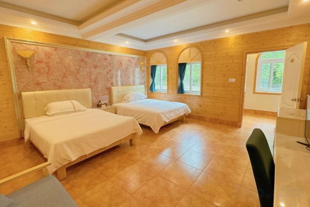 Een slaapkamer met twee bedden, een houten vloer en een deur naar een badkamer.