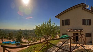 A house with a pool, outdoor seating, and a view of the hills.