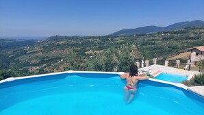 A person in a swimming pool with a view of a mountainous landscape.