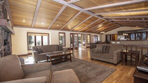 A spacious living area with high ceilings and wooden beams, featuring two sofas and a coffee table. - Highlands Lodge by Hauserman Rental Group (Tahoe City)