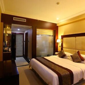 A hotel room with a large bed, a nightstand, a lamp, and a mirror. - Hongteng Hotel (Chengdu)