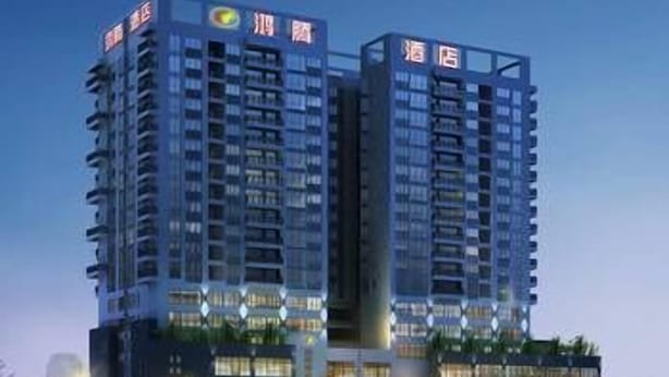 Un hôtel de grande hauteur, doté de nombreux étages, qui se distingue par son architecture moderne, avec de grandes fenêtres et des balcons.