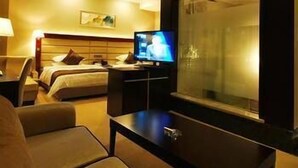Une chambre d’hôtel avec un lit, une télévision, un bureau et une fenêtre.