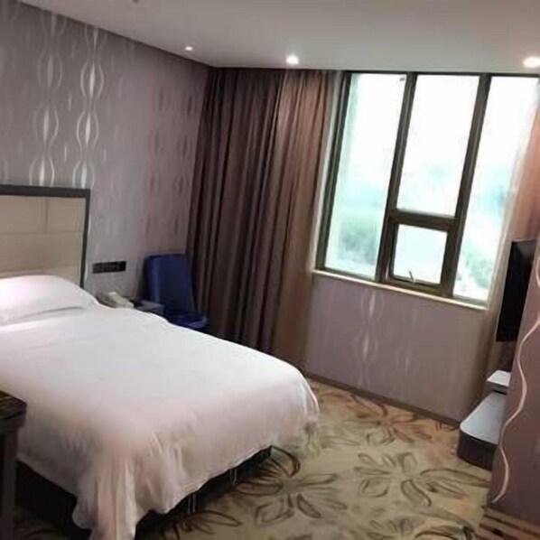 A hotel room with a bed, a chair, a desk, and a window. - Chenmao Yuyang Hote (Guigang)