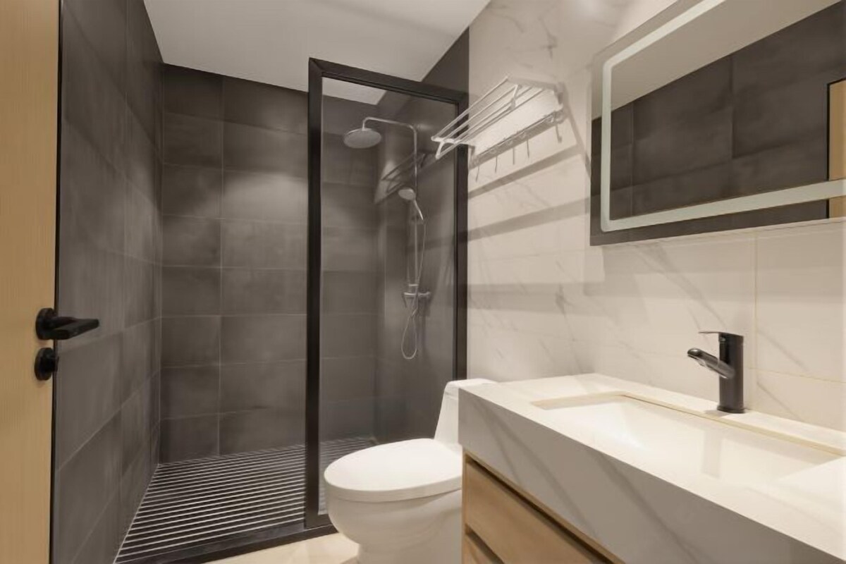 Un baño moderno con ducha, inodoro y lavamanos.