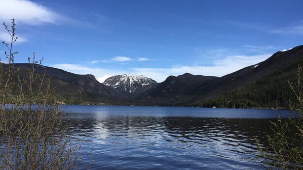 Un llac tranquil enclavament entre muntanyes i sota un cel serè.