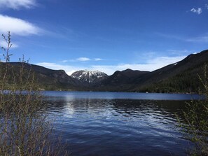 Un lac paisible, entouré de montagnes et surplombé d’un ciel dégagé.