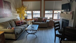 A living room with a sofa, a coffee table, a fireplace, and a television. - Our studio condo is the closest condo to the Eagle Lift.  Just steps away. (Frisco)