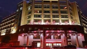 A multi-story hotel with a central entrance and a parking area in front. - Modern Square Hotel (Lishui)