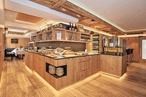 Una cocina moderna con armarios de madera, una isla central y diversos alimentos y utensilios de cocina.