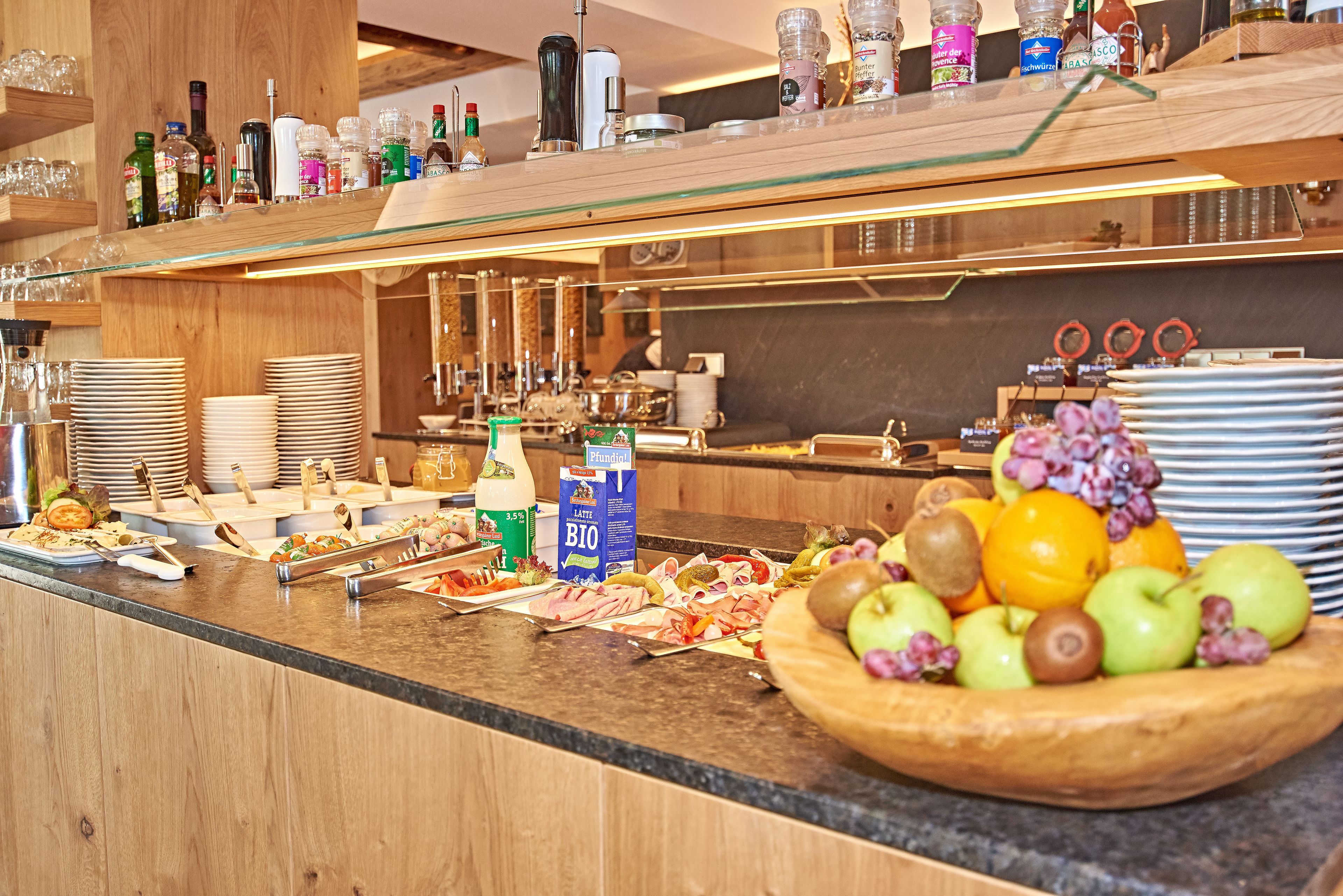 A buffet setup with various food items, including fruits and a coffee station.