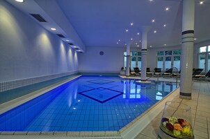 Una piscina techada, sillones reclinables de piscina