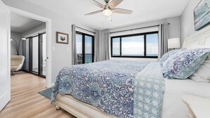 A bedroom with a large bed, a ceiling fan, and a view of the sky through the windows. - BEACHFRONT-9th floor view, recently updated-avail Sept 7-12, 19-23, Oct 18-25 (Destin)