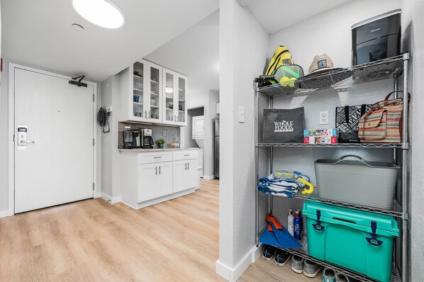 A modern kitchen with white cabinets and a built-in coffee machine.