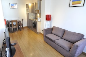 Apartamento, 2 quartos | Sala de estar | TV de tela plana