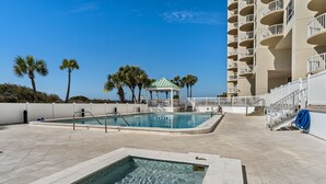 A pool area with a hot tub, a gazebo, and a staircase leading to an upper level. - 2BR Beachfront Condo at Hidden Dunes! Beach Views, 3 Tropical Pools, Hot Tub. (Miramar Beach)