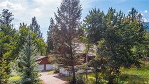 A rural property with a gravel driveway leading to a white building with a brown roof. - RMR: Stock House in Teton Village (Teton Village)