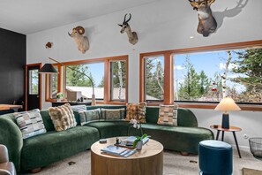 A modern living room with a sectional sofa, a round coffee table, and a lamp.