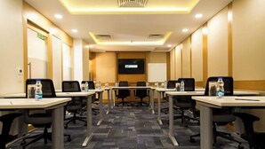 A conference room with multiple tables and chairs, a large screen, and a carpeted floor. - STEPiNN - Ess Kay Ess Villa (Gurugram)