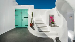 A white-walled interior with a turquoise door, a staircase, and potted plants. - Sophia Finikia Villas (Santorini)