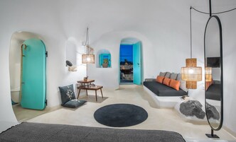 Una sala de estar moderna con un sofá, un tapete redondo y una zona de comedor con mesa y sillas.