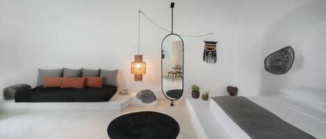 A modern bedroom with a bed, a round mirror, a hanging light, and a wall-mounted decorative piece.