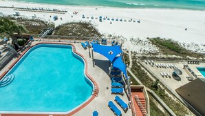 A resort with a swimming pool, beach access, and lounge areas.