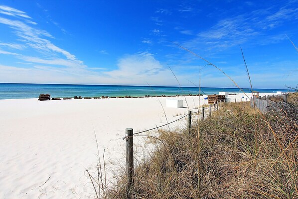 A beach with a sandy shore, wooden structures, and a clear blue sky.