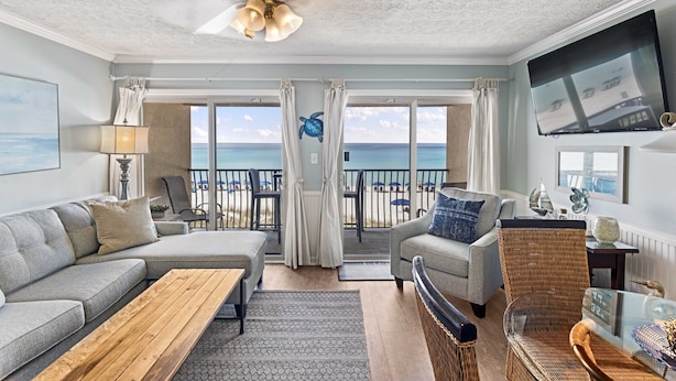 A spacious living room with a large window overlooking the ocean, furnished with a sofa, chairs, and a coffee table. - 21- Best Views of the BEACH from the balcony of this beautiful condo! (Destin)