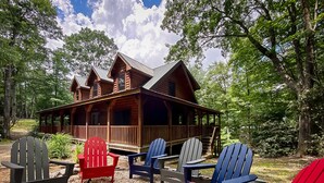 A cabin with a porch, surrounded by Adirondack chairs and a fire pit. - Large Cabin Near Downtown Blowing Rock (Blowing Rock)