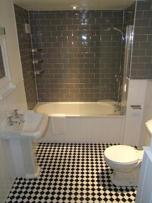A bathroom with a bathtub, a sink, and a toilet. - The Fleur de Lys Inn (Wimborne)