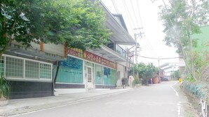 Una calle con un edificio que tiene un amplio ventanal y un letrero con caracteres chinos.