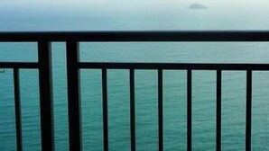 A view of the sea from a balcony with a railing. - Mingju Holiday Hotel (Yangjiang)