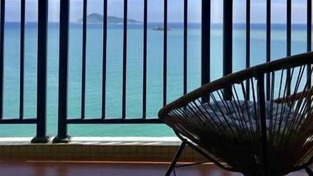 A balcony with a view of the sea and a chair. - Mingju Holiday Hotel (Yangjiang)
