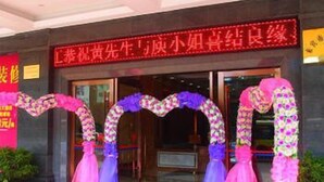 A hotel entrance with a red carpet and floral arches.
