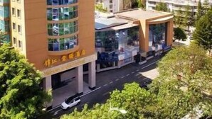 A multi-story building with a modern architectural design, featuring a prominent glass facade and a covered entrance area. - Jinjiang Jinqiao Hotel (Liangshan Yi)