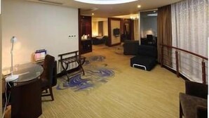 A hotel room with a round ceiling light, a dining area with a table and chairs, and a living area with sofas and a TV. - Jinjiang Jinqiao Hotel (Liangshan Yi)