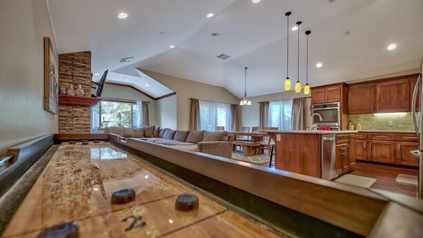 Una cocina moderna con armarios de madera, una isla central e iluminación colgante.