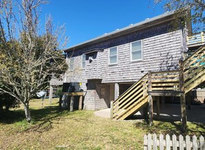 Un bâtiment en bois à deux étages, avec un escalier en bois menant à l’entrée.