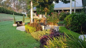 A well-maintained garden with a variety of plants and a seating area. - 'Little Britton' self contained accommodation (Wingham)