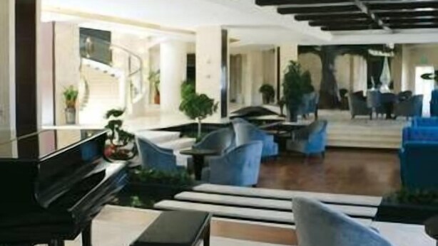 Eine geräumige Lobby mit einem Flügel, bequemen Sitzgelegenheiten und einem modernen Deckenstil.