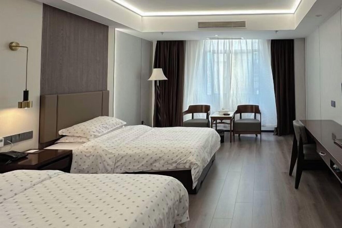 Una habitación de hotel con dos camas, un escritorio y una silla.