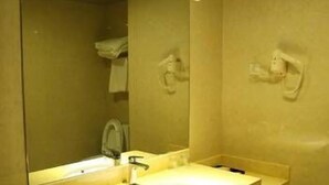 A bathroom with a sink, mirror, and towel rack. - Windsor Hotel (Zhangzhou)